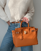Bolso de cuero Mila de Veyro Madrid, en color marrón, con asa ajustable y detalles elegantes, sobre fondo neutro.