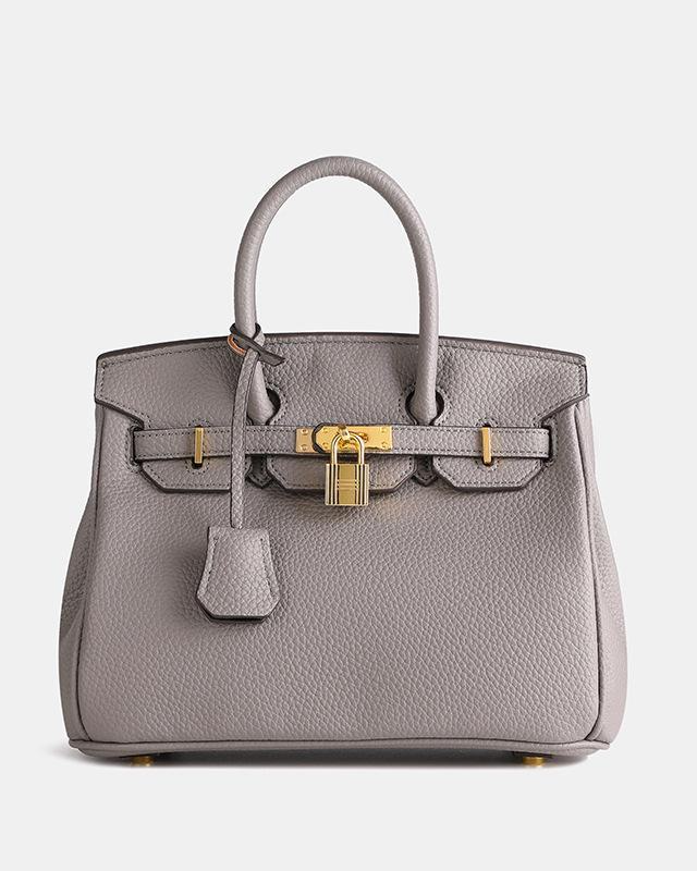 Bolso de cuero MILA de Veyro Madrid, en color marrón, con asas cortas y cierre metálico, sobre fondo neutro.