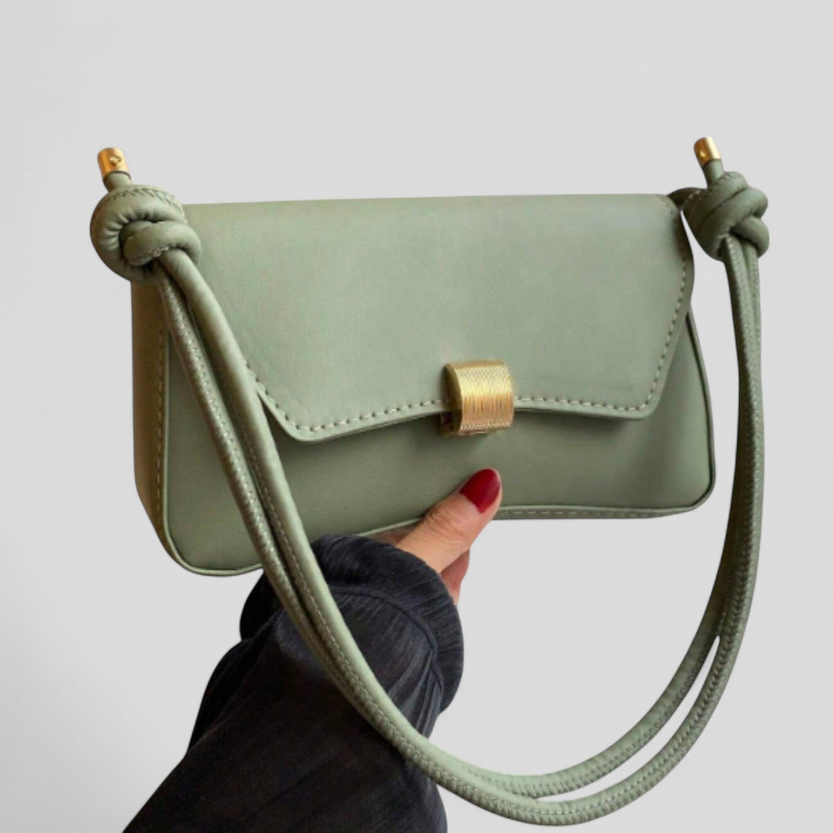 Bolso de mano Veyro Madrid Etelvina en piel con detalles elegantes y asa superior sobre fondo neutro.