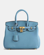 Bolso de cuero Veyro Madrid Mila, en color negro con detalles en marrón y asa de mano, diseño elegante y clásico.