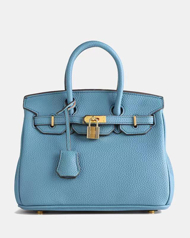 Bolso de cuero Veyro Madrid Mila, en color negro con detalles en marrón y asa de mano, diseño elegante y clásico.