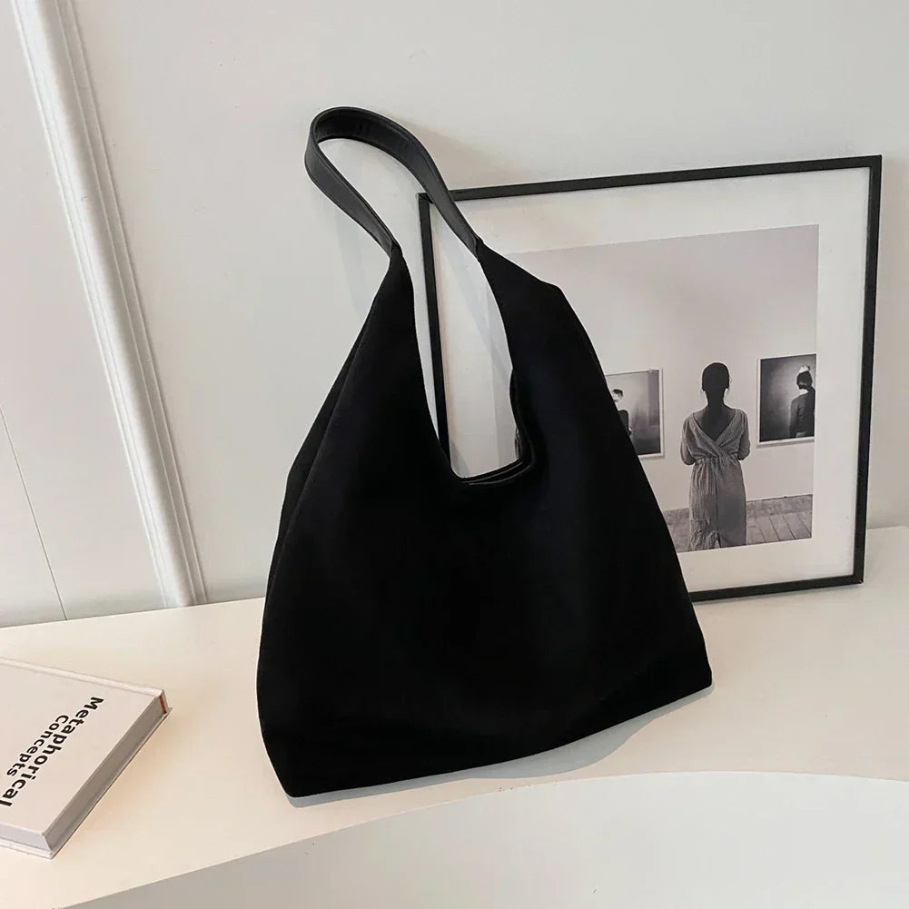 Bolso de ante Lola Veyro Madrid con asa, en color marrón claro y diseño elegante, sobre fondo neutro.